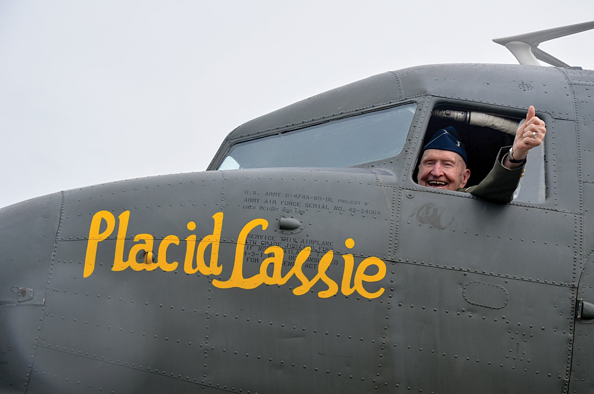 Colonel Gail Halvorsen gives a thumbs up in an airplane