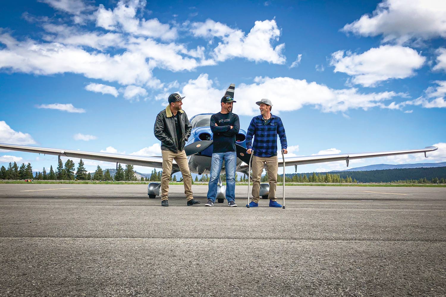 three men standing in front of an airplane