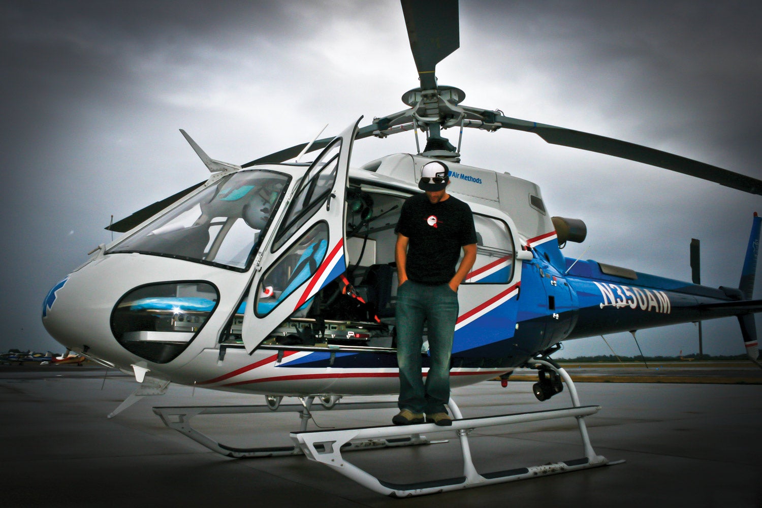 man standing on step of helicopter