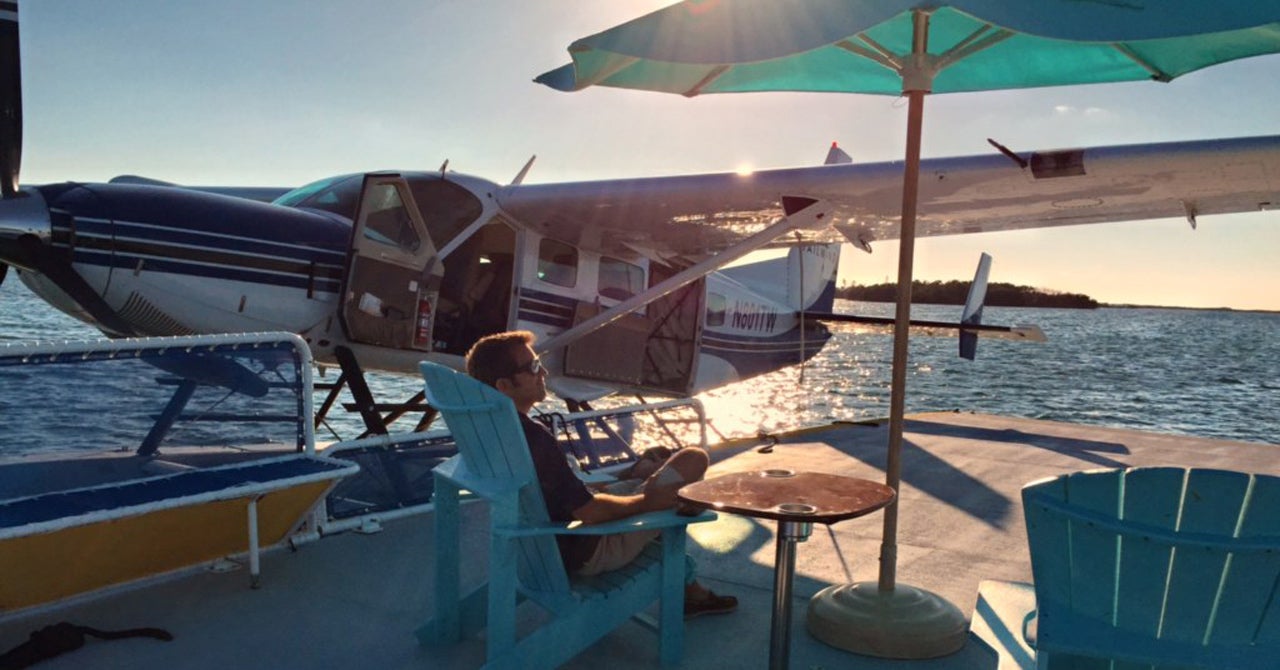 man sitting on dock next to seaplane