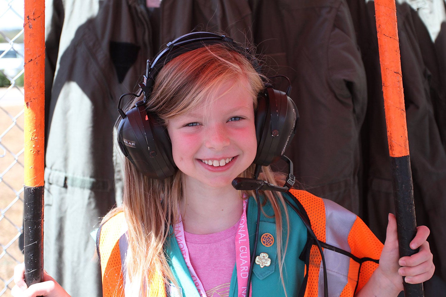 A young girl tries on an aviation headset