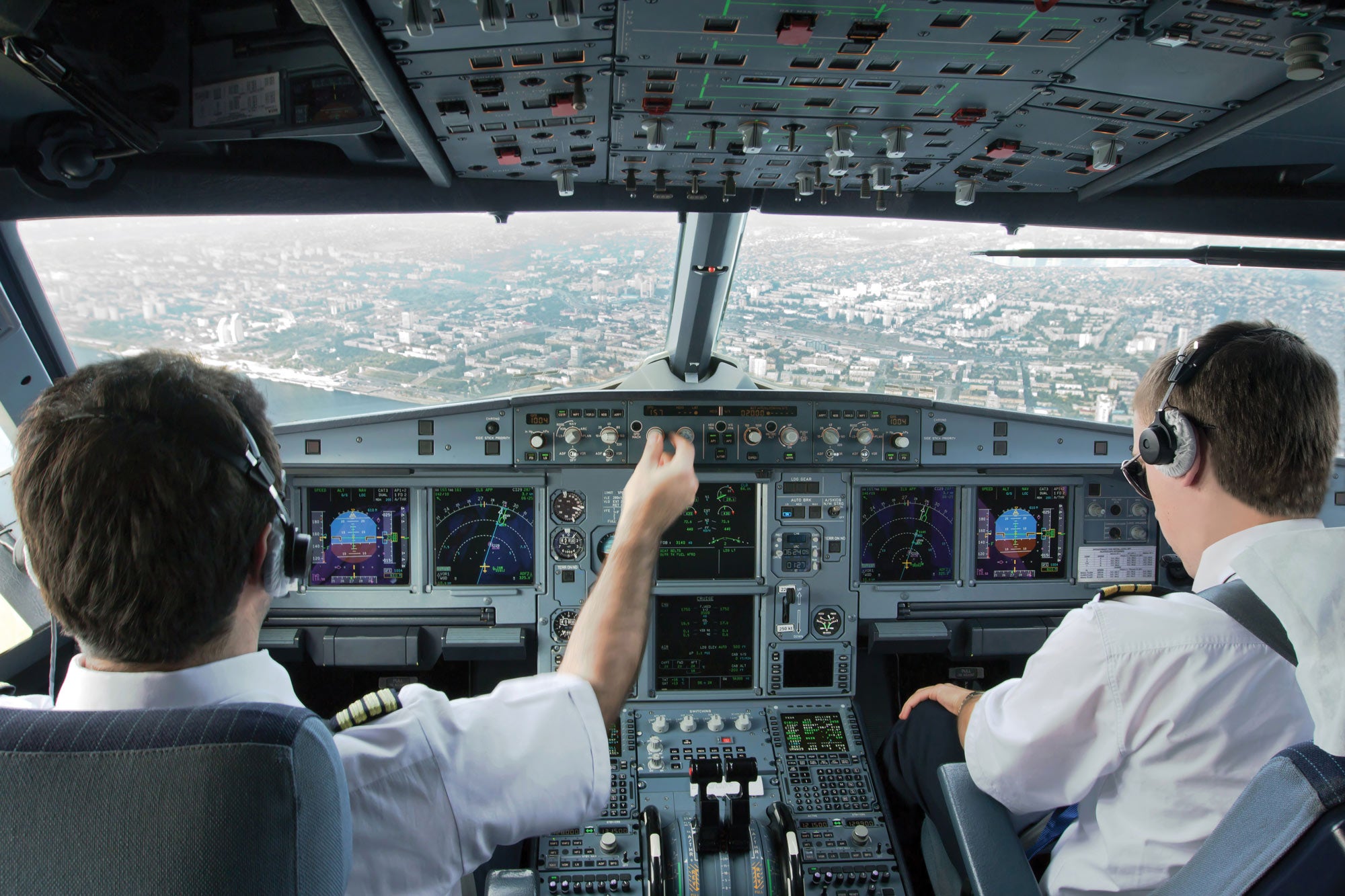 Two pilots in control of a large aircraft.
