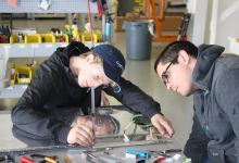 High school students work on an airplane wing.[Credit: GAMA]