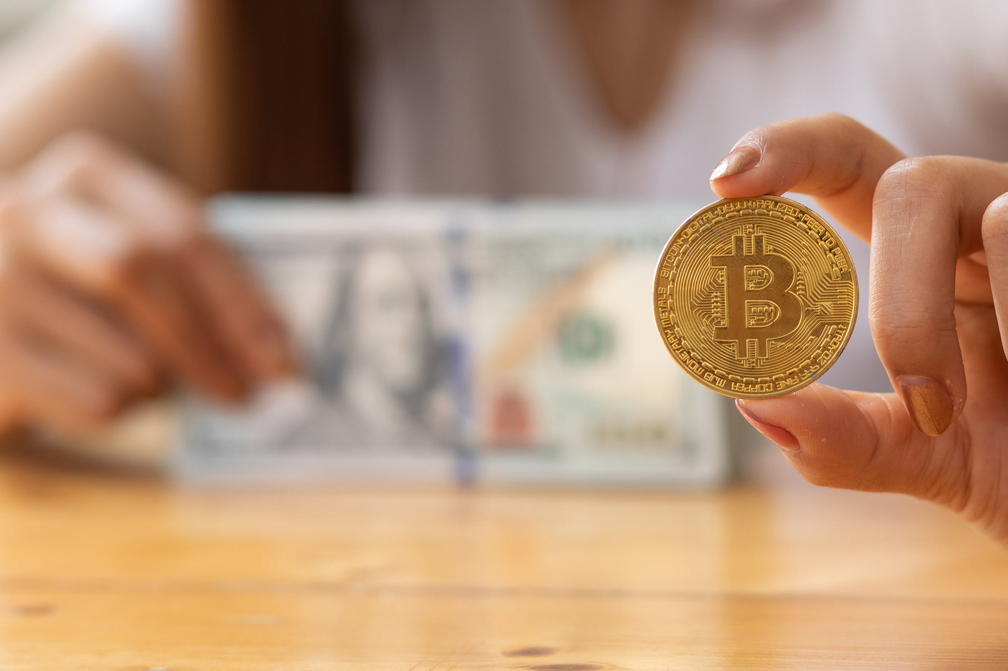 Woman hand holding bitcoin and dollars