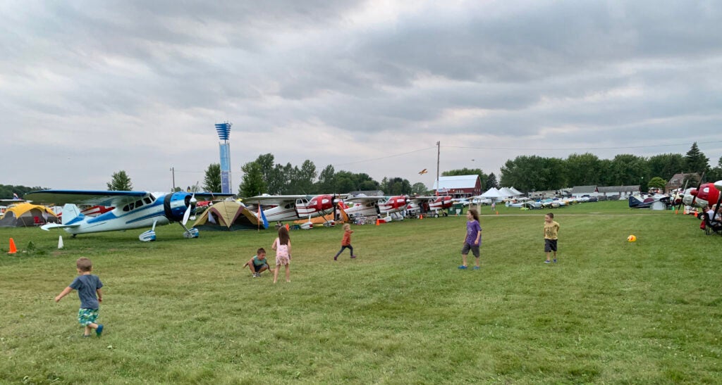 Children play amongst the vintage Cessna 195s at AirVenture.