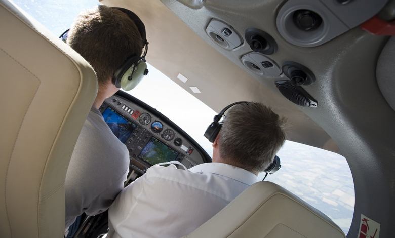 A student pilot and CFI as seen from the back seat of a small airplane