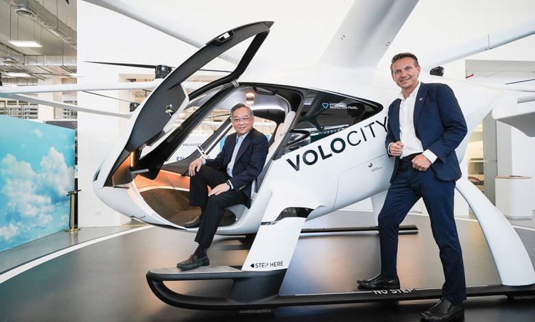 Singapore and Volocopter officials pose in a VoloCity prototype eVTOL air taxi