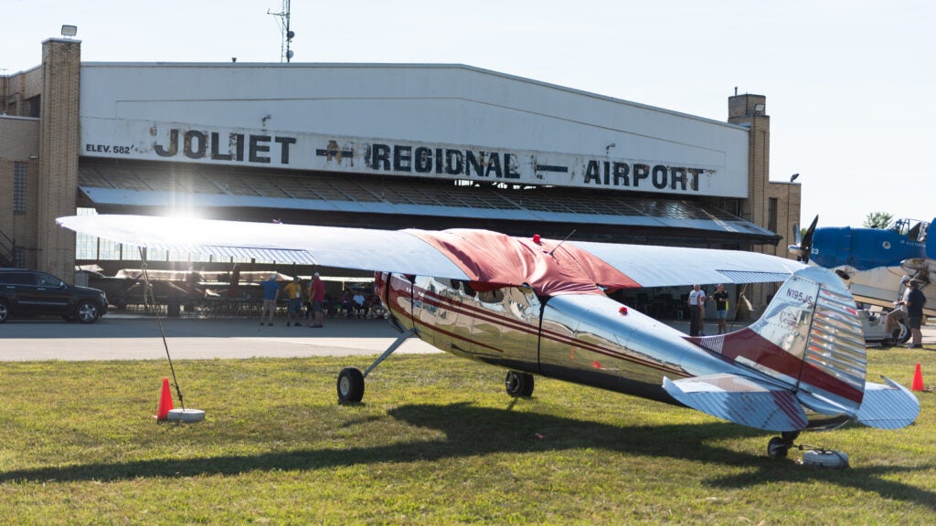 Cessna 195 in front of hangar