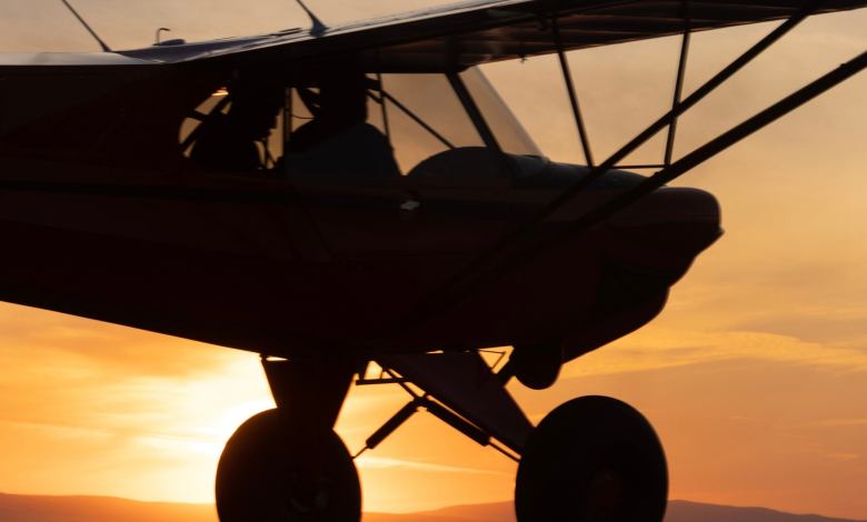 A small aircraft soars through the skies at sunset.