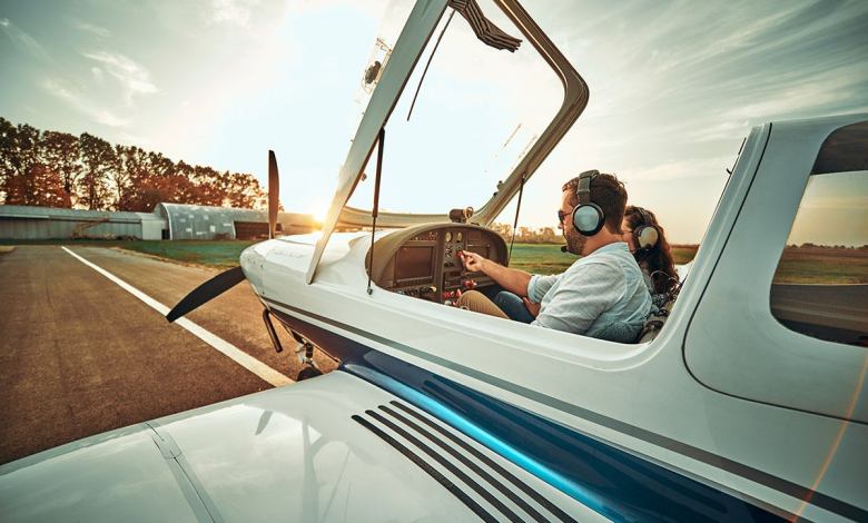 Pilot with co-pilot prepare take off in a small aircraft. Side view. Sunset background