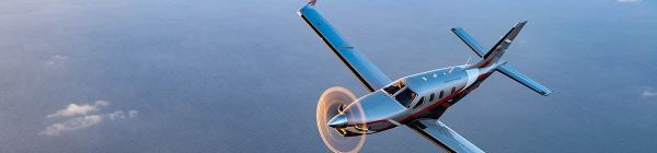 A Daher TBM 960 airplane soars in the sky at sunset