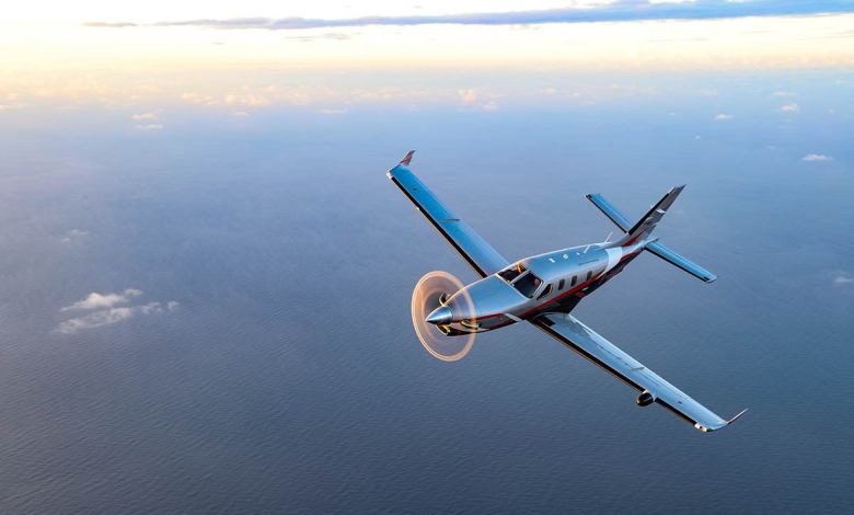 A Daher TBM 960 airplane soars in the sky at sunset