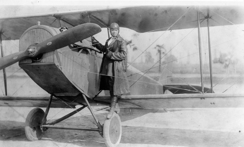 Bessie Coleman stands with her aircraft in 1922.