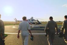 Test pilots walk toward a Leonardo SW4 helicopter equipped with Daedalean’s visual air traffic detection system. [Credit: Daedalean]