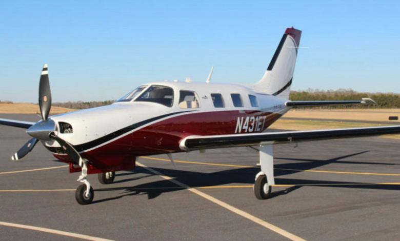 A single-engine piston aircraft sitting on an airport tarmac.