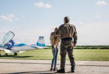 Girl standing with father in front of plane