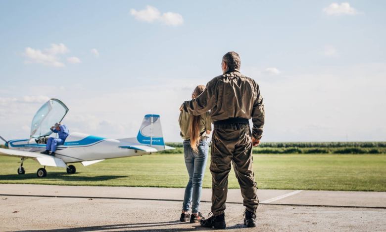 Girl standing with father in front of plane