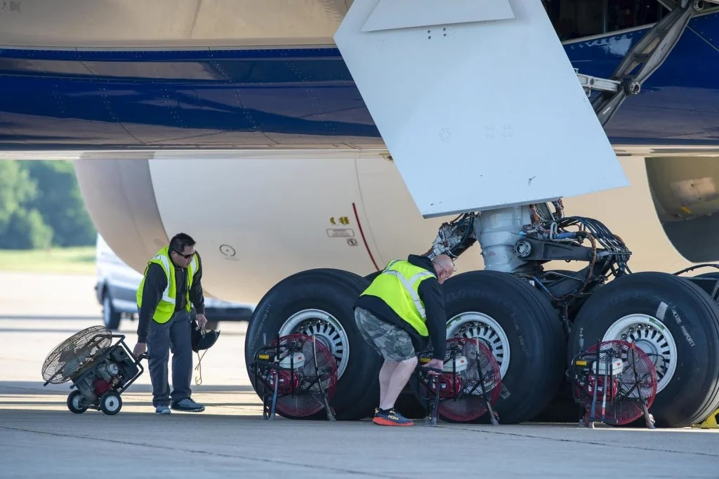 Boeing workers position fans to cool the 777X's wheels and brakes after testing. [Credit: Boeing/Paul Weatherman]