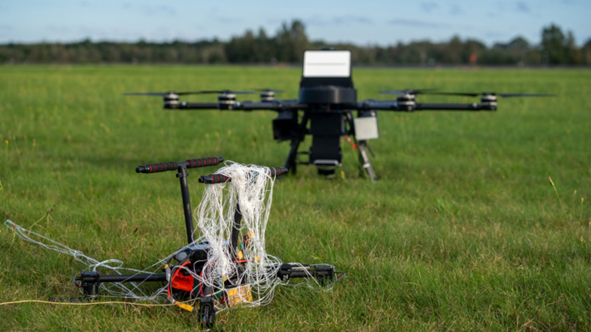 UAS drone caught in a net on grass field