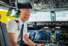 An ATP Flight School graduate and United Airlines Captain sits in the cockpit of a passenger jet.