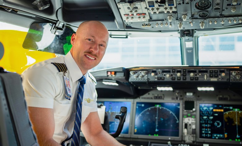 An ATP Flight School graduate and United Airlines Captain sits in the cockpit of a passenger jet.
