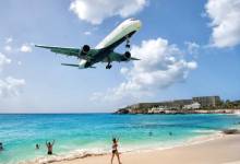 A widebody jet overflies the beach on short final to the runway at St. Maarten in the Caribbean. [Credit: Adobe Stock]