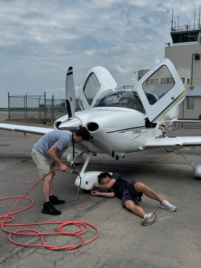 Blake Freedland (right) adds air to the 
Cirrus’ front gear wheel at Campbell River Airport in Canada. [Credit: Vlada Bykova]