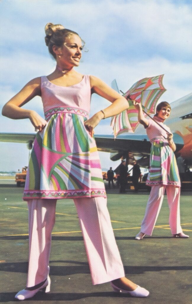 Braniff International Airways flight attendants in Emilio Pucci’s 1971 uniform collection featuring psychedelic pink swirls and umbrellas. [Credit: Museum of Flight]