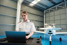 Pilot using laptop in hangar [Credit: Shutterstock]
