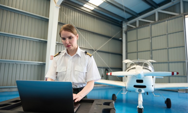 Pilot using laptop in hangar [Credit: Shutterstock]
