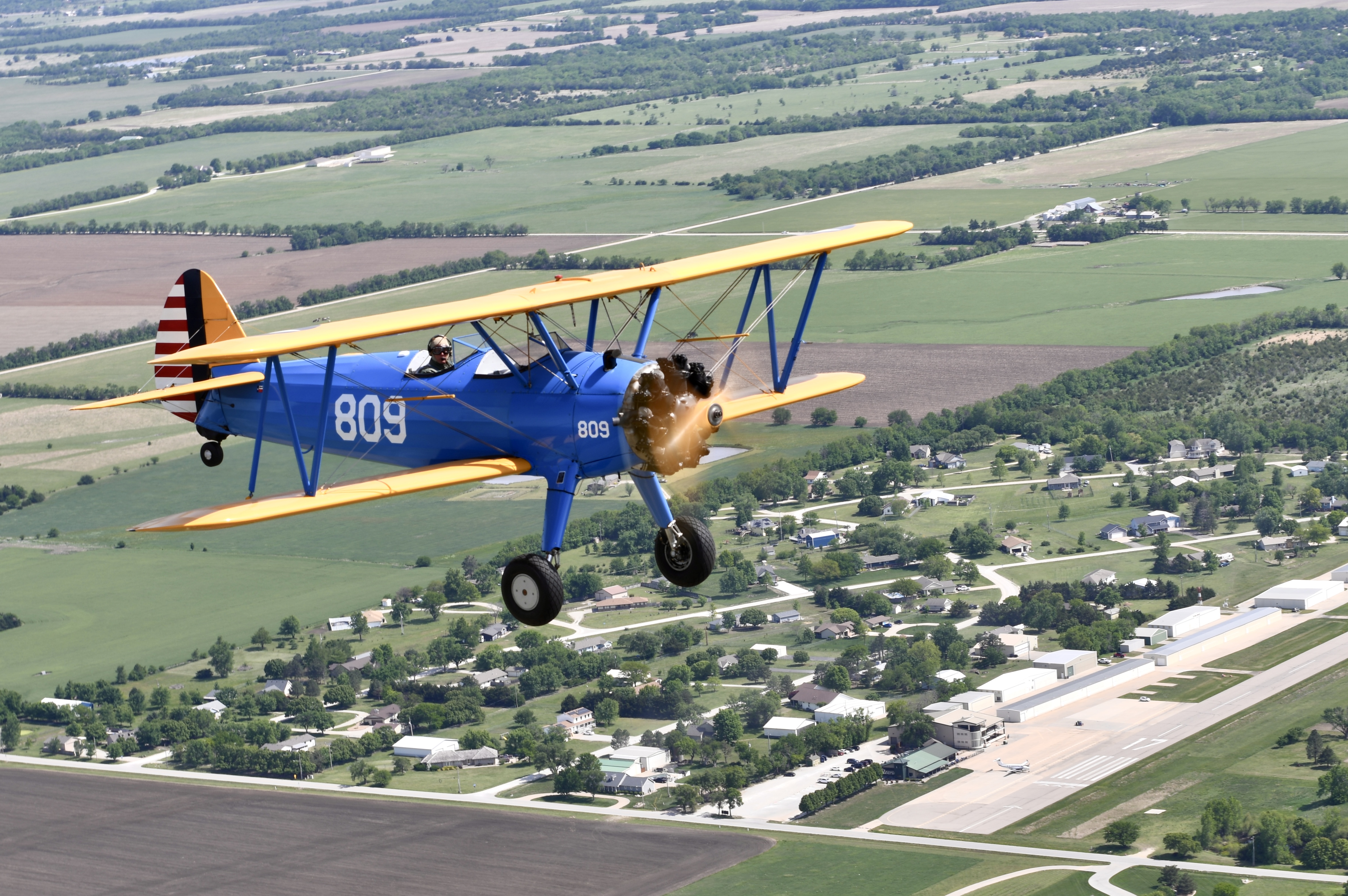 Stearman biplane flying over Stearman Field Airport (1K1) in Benton, Kansas [Credit: Grant Boyd]