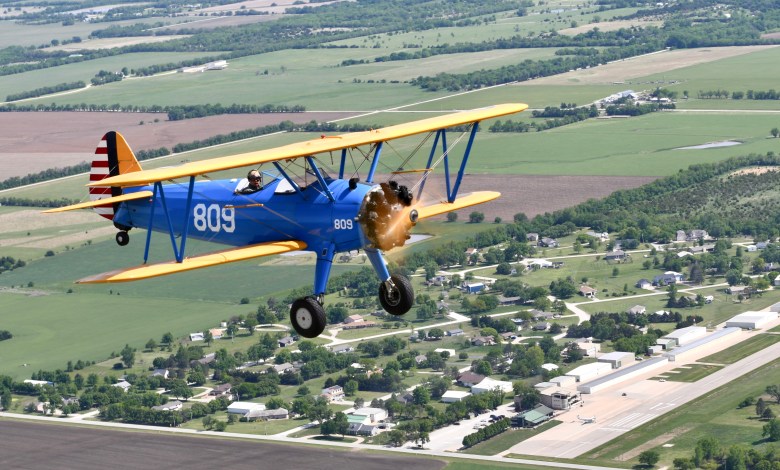 Stearman biplane flying over Stearman Field Airport (1K1) in Benton, Kansas [Credit: Grant Boyd]