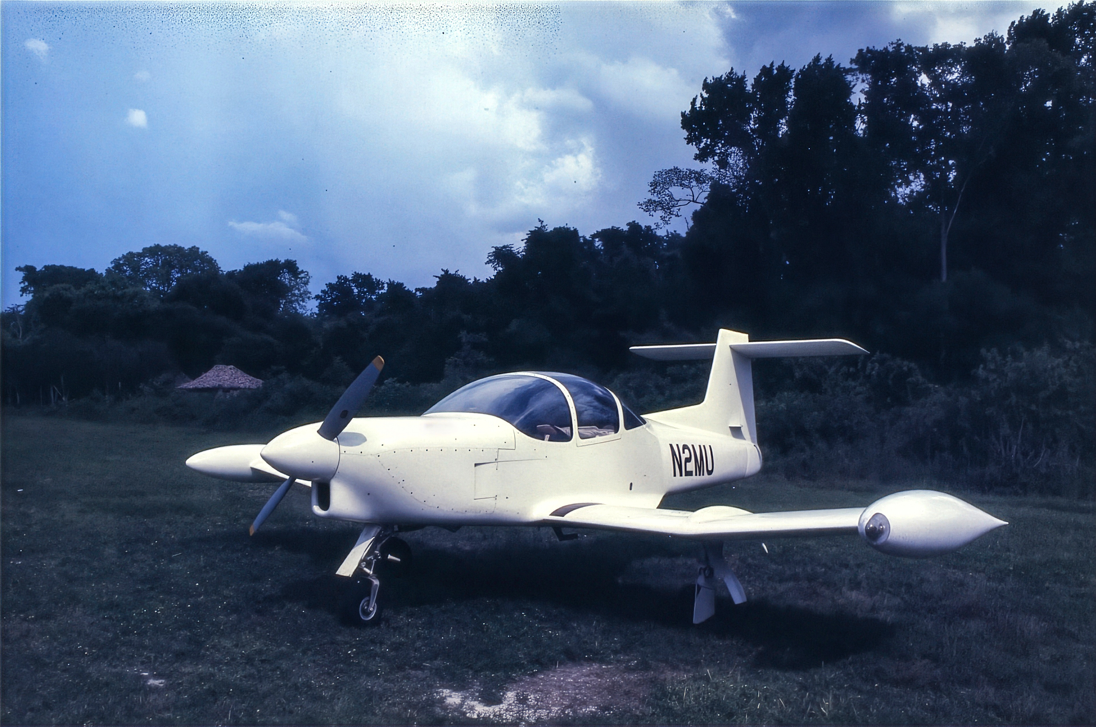 The author’s airplane sits on the grass near the ancient temple site of Tikal in Guatemala. [Credit: Peter Garrison]
