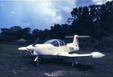 The author’s airplane sits on the grass near the ancient temple site of Tikal in Guatemala. [Credit: Peter Garrison]