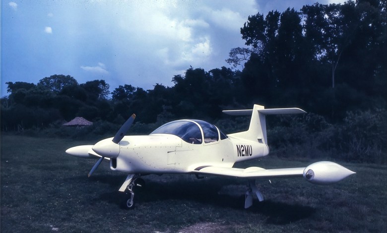 The author’s airplane sits on the grass near the ancient temple site of Tikal in Guatemala. [Credit: Peter Garrison]