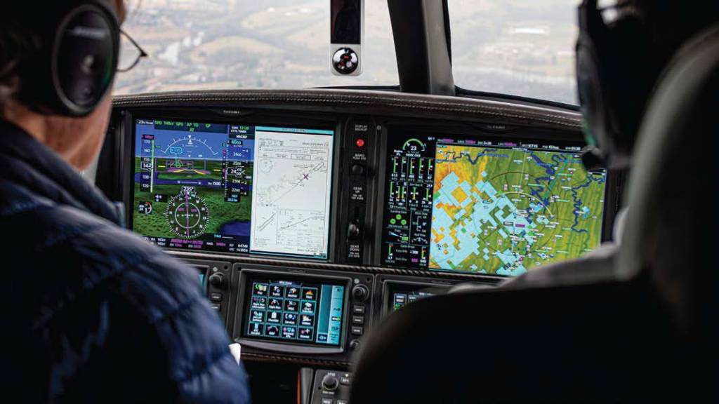 The Garmin flight deck centers on dual 14-inch LED displays, with three touchscreen controllers below for data entry and control of display panes and the integrated nav/com system. [Credit: Erin Armstrong]