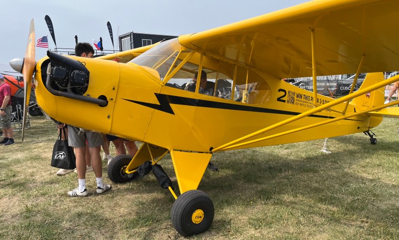 One of three J-3 Cubs being raffled off by the Jim Richmond Backcountry Aviation Foundation is on display at Oshkosh near the CubCrafters booth. [Credit: Meg Godlewski]