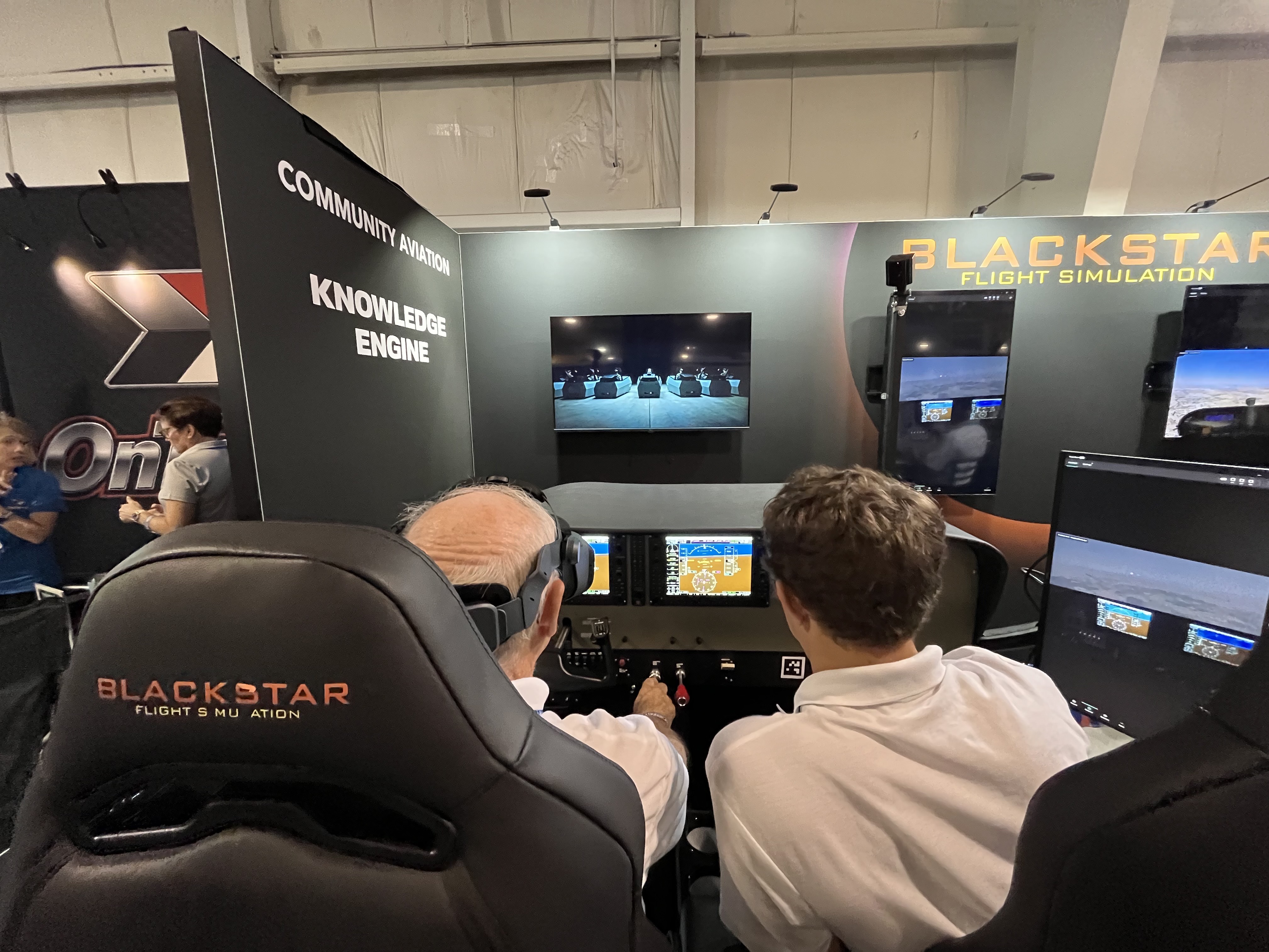 Attendees try out the Blackstar Eclipse Advanced Aviation Training Device at AirVenture. [Credit: Meg Godlewski]