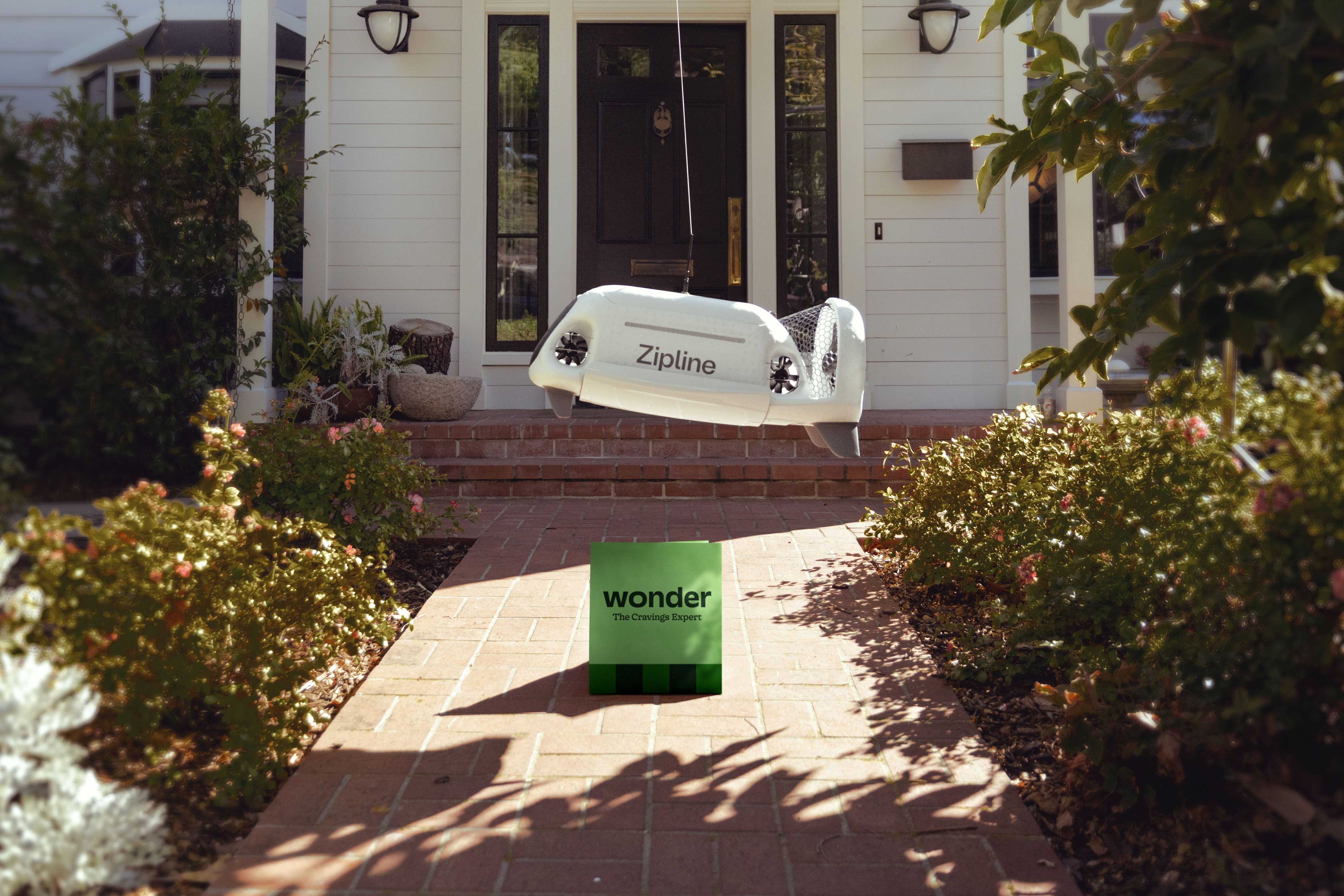Zipline delivery drone lowering a droid and package from Wonder on a tether
