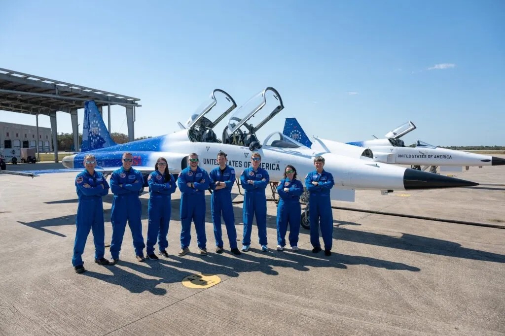 NASA administrator Jared Isaacman and agency personnel stand in front of Isaacman's personal F-5 Tiger II fighter jet