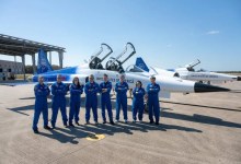 NASA administrator Jared Isaacman and agency personnel stand in front of Isaacman's personal F-5 Tiger II fighter jet