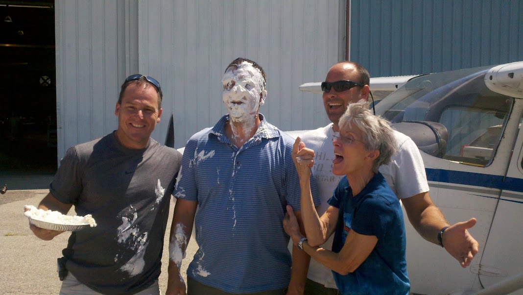 The author (far right) has cut off a few shirttails and plopped a few pies in the faces of first-solo pilots. [Credit: Martha Lunken]