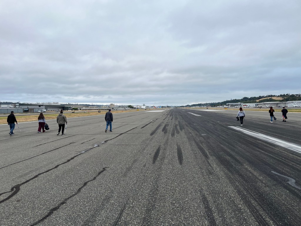 Volunteers walk the runway looking for debris on Boeing Field FOD Day 2026. [Credit: Meg Godlewski]