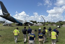 NTSB personnel approach Amazon Prime Air 21 Air Boeing 767-33A cargo jet wreckage at Miami International Airport