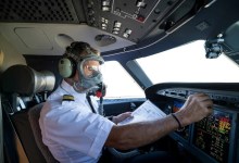 pilot in cockpit wearing oxygen mask