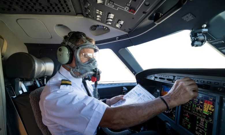 pilot in cockpit wearing oxygen mask