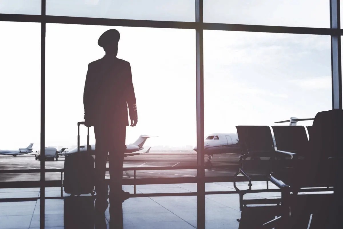 Silhouette of pilot standing in airport terminal