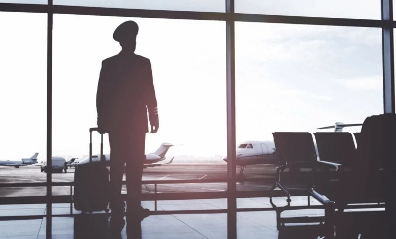 Silhouette of pilot standing in airport terminal