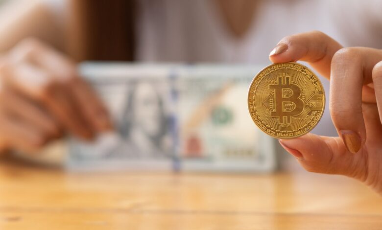 Woman hand holding bitcoin and dollars