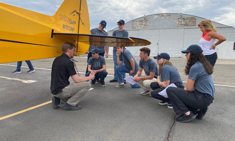 High school students looking at a CubCrafters NX aircraft
